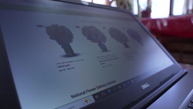 A laptop with bouquets from SarataFlowers.com displayed 